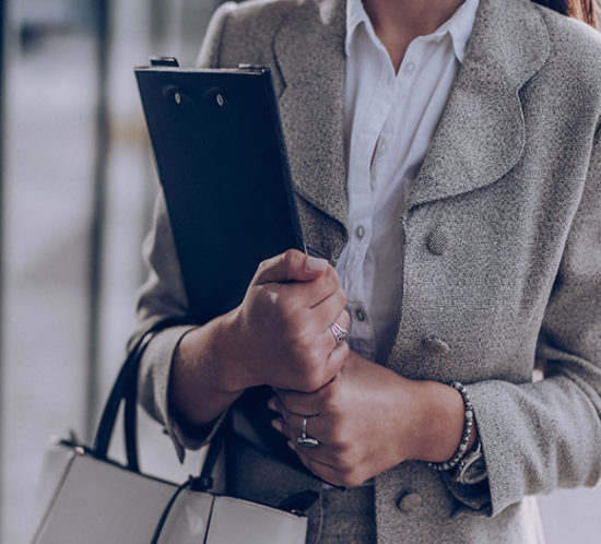 Woman carrying a bag and clipboard understanding accident, sickness and unemployment insurance with Insure 313.