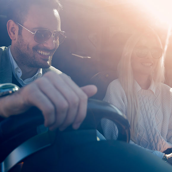 A couple driving in the sun insured with Insure 313's personal motor insurance.
