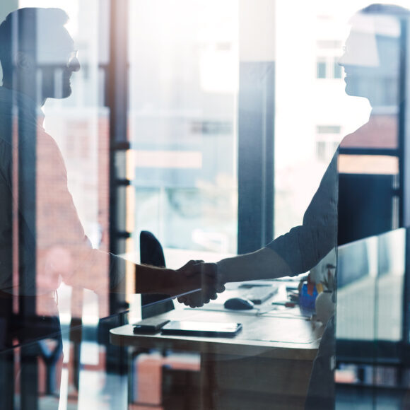 Shot of two businessmen shaking hands in an office - become an introducer with Insure 313